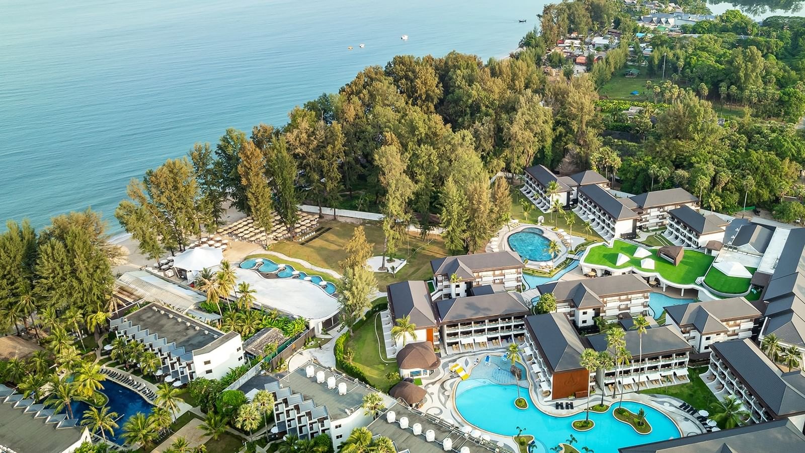 Luchtfoto van Amora Beach Resort: zwembaden naast Bang Tao Beach in Phuket